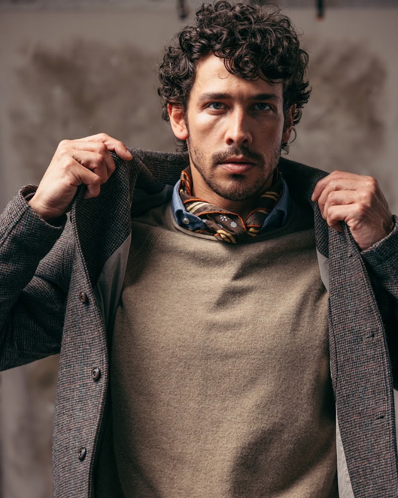A knit sport jacket worn open over a lambswool sweater and silk neckerchief